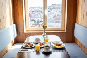 里斯本里斯本佩索阿酒店的一张桌子,上面放着两盘食物和一个窗口