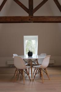 EsneuxUn Toit sur les Monts的餐桌、白色椅子和窗户