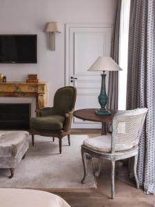 巴黎New Hotel Roblin的客厅配有椅子和带台灯的桌子