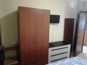 洛阿诺HOTEL GIORDANA的一间卧室配有一张位于床边的大型木制橱柜
