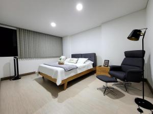 麦德林New Luxury 3 Bedroom Apartment in Great Area.的一间卧室配有一张床和一把椅子