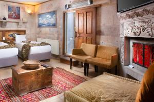 乌奇希萨尔Cappadocia Fairy Chimneys Selfie Cave Hotels - Special Class的酒店客房设有两张床和壁炉