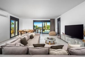 克雷马斯蒂Penélope Beachfront Villa的客厅配有大沙发和平面电视