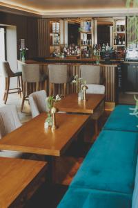 MellorEverything Retreat的一间带木桌椅的餐厅和一间酒吧