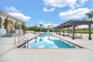 奥兰多8543 - 4BR Disney World Vacation Townhome的一个带长椅和凉亭的游泳池