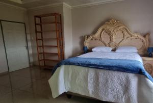 SitekiSapphire Lodge的一间卧室配有一张大床,提供蓝白色的毯子