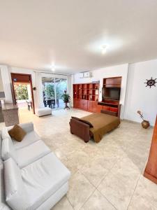 普拉亚斯Casa con piscina y salida a la playa的客厅配有白色沙发和电视