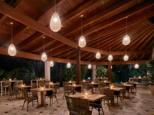杰若米斯Calaserena Resort的一间带桌椅和灯光的餐厅