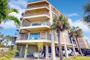 圣徒皮特海滩Gulf Strand Resort 308的一座高大的建筑,前面有棕榈树
