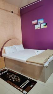 马尔万KonkanParadise,Hotel Malvan Beach的紫色墙壁间的一张床位