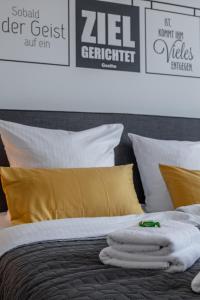 奥厄Goethe Palais Suite Anna Amalia l 1-8P l Lift l Parkplatz的一张带白色床单和黄色枕头的床