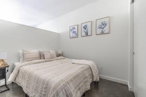 西雅图Seattle Lux 1 bd Apartment- Rooftop, WiFi, Pet Friendly的白色卧室配有一张床,墙上有三张照片