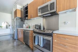 西雅图Seattle Lux 1 bd Apartment- Rooftop, WiFi, Pet Friendly的厨房配有不锈钢用具和木柜