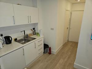 伦敦Luxury 1-Bed Apartment in London的厨房配有白色橱柜和水槽