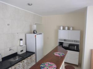 康赛瓦托利亚Apartamento 2 quartos em Conservatória - até 7 pessoas!的厨房配有木桌和冰箱。