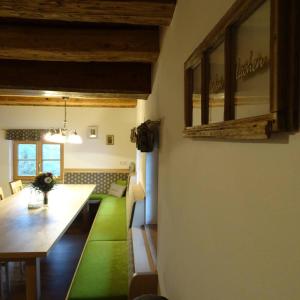 菲施巴赫Beim Bergbauer的一间用餐室,配有长桌和绿色地毯