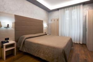都灵嘉林佩缇酒店的一间卧室设有一张大床和一个窗户。