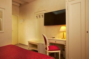 都灵嘉林佩缇酒店的一间设有一张桌子和一台墙上的电视的房间