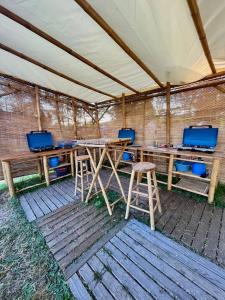 塞莱特Lodg'ing Nature Camp Châteaux de la Loire的帐篷下配有木桌和凳子