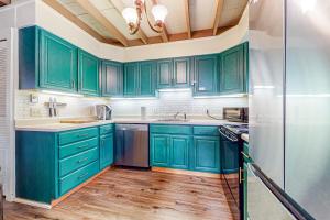 DoverLower Highlands Hideaway的铺有木地板,设有绿色橱柜的厨房