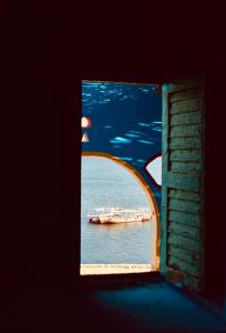 阿斯旺Heissa Hostel的船在水中透过窗户