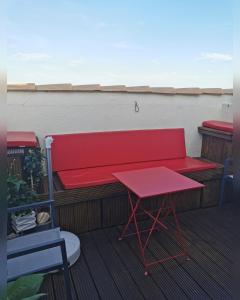 阿格德角Chambres d'Hotes NATURISTE, Village Naturiste Cap d'Agde, Draps, Serviette, Café, Menage inclus en fin de sejour的阳台的红色长凳和桌子