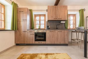 阿尔滕马克特蓬高Haus.1800的厨房配有木制橱柜和炉灶。