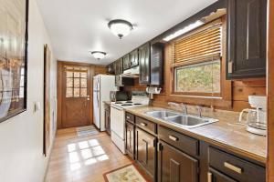 布洛英罗克山Picturesque Riverside Cabin with Fireplace and Porch的厨房配有木制橱柜、水槽和窗户。