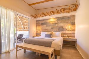 塔马林多Les Voiles Blanches - Luxury Lodge的一间卧室设有一张床和木墙
