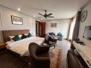 木尔坦Elegant Executive Suite的一间卧室配有一张床、两把椅子和一张沙发