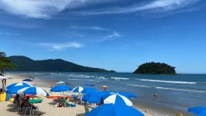乌巴图巴Kaliman Luxo Pousada的海滩上有人,有蓝色和白色的遮阳伞