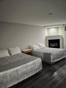 勒杜克Western Budget Motel #1 Leduc/Nisku的带壁炉的酒店客房内的两张床