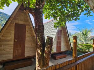 阿布拉奥Raio de Sol pousada & camping的木结构建筑,两扇门在树旁