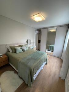 伊塔佩马Apart moderno 3 suites 2 vagas de garagem e quadra do mar的一间卧室配有一张大床和镜子