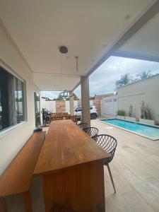 盖比姆Guaibim House- Sua casa de praia的一个带游泳池的房间里一张大木桌