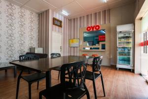 班吉OYO 44094 Bangi Lanai Hotel的一间带桌椅和冰箱的用餐室
