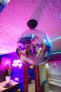 拉卢维耶尔Capsule Boogie-Woogie - JACUZZI - SAUNA - BILLARD - JEUX - ECRAN GÉANT - FILET SUSPENDU - NETFLIX的舞会挂在紫色天花板上