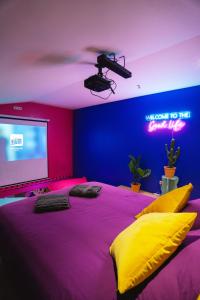 拉卢维耶尔Capsule Boogie-Woogie - JACUZZI - SAUNA - BILLARD - JEUX - ECRAN GÉANT - FILET SUSPENDU - NETFLIX的一间卧室配有一张大床和投影屏幕