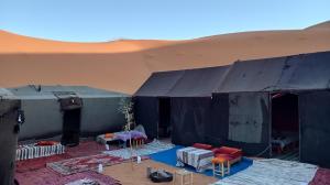 AdrouineGambe Camp的沙漠中的帐篷,配有桌椅