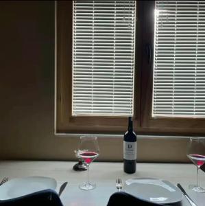 姆尔科尼奇格勒Bungalow Damiano's的一张桌子,上面放着一瓶葡萄酒和两杯酒