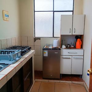 奇瓦伊Apartamento Colca 's Home, cuenta con dos habitaciones的厨房配有炉灶和冰箱。