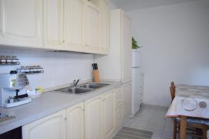 卡利亚里La Casa del Carrubo的厨房配有白色橱柜和水槽