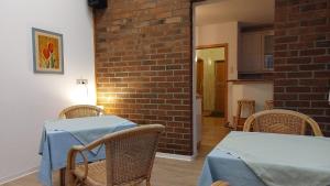 罗埃特根Pension Britta的一间设有桌椅和砖墙的用餐室