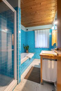 梅森韦曾图艾尔坎提科住宿加早餐旅馆的蓝色瓷砖浴室设有浴缸和水槽