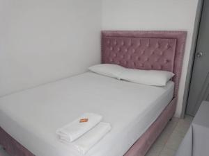 巴耶杜帕尔Hotel Mileniun Valledupar的白色的床、粉红色床头板和白色枕头