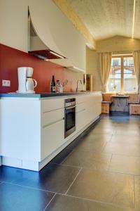 卡斯特尔罗托拉兹舍弗农家乐的一间设有白色橱柜和瓷砖地板的大厨房