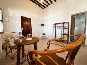 江比阿HA Beach Hotel Zanzibar的一间客房内配有桌椅的房间