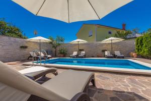 马林斯卡Guest House Antonella的房屋旁的游泳池配有椅子和遮阳伞