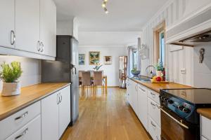 TanangerLarge home in Sola的厨房铺有木地板,配有白色橱柜。
