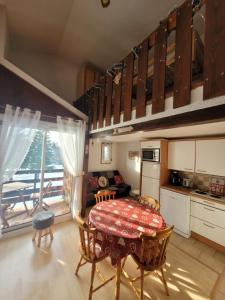 莱鲁斯Le Chalet, Superbe Duplex 3 étoiles proche du centre des Rousses, 5 personnes, Draps inclus的带桌子的厨房和带阳台的厨房